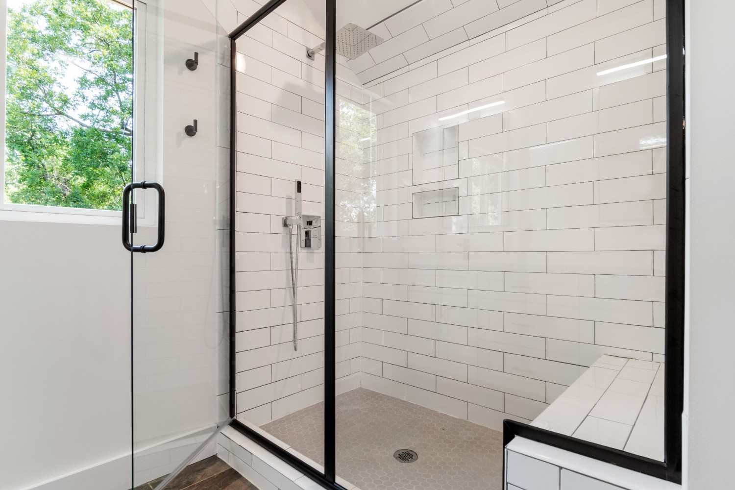 Sleek and modern shower with glass panels and tiled walls in a bright bathroom